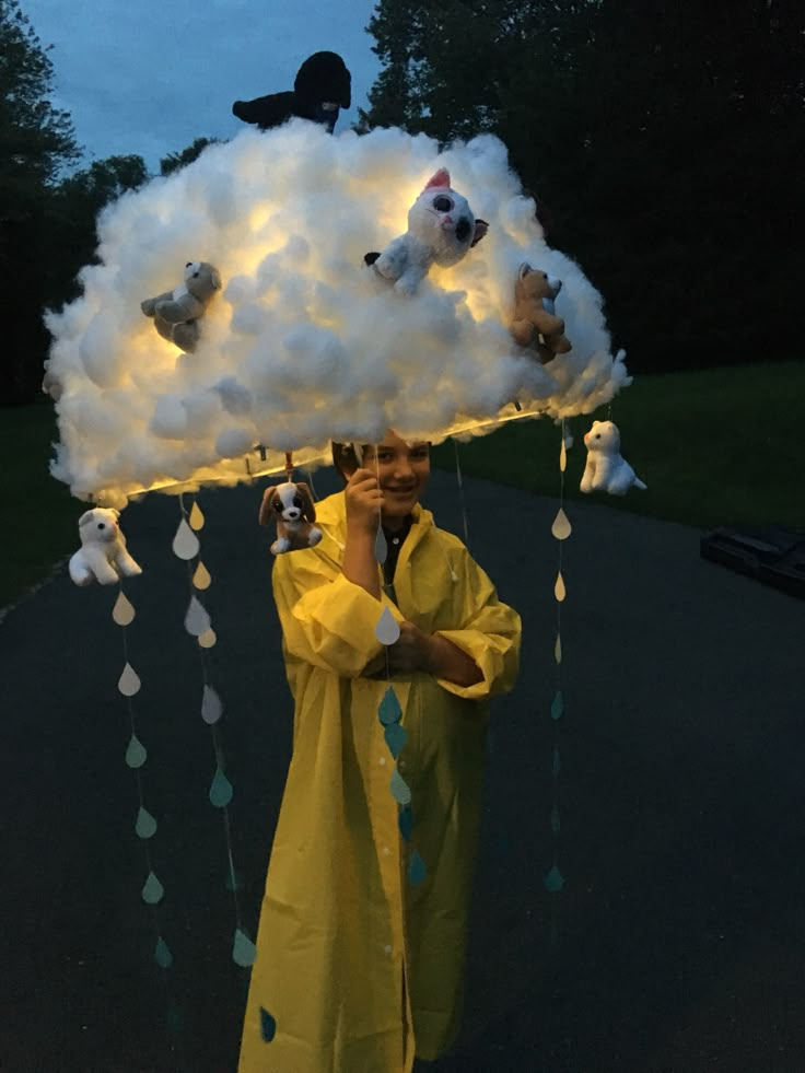 a man in yellow raincoat holding up a cloud with stuffed animals on it