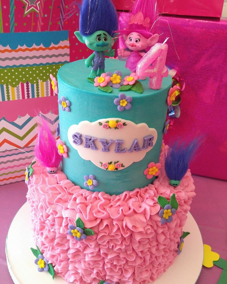 there is a birthday cake with pink and blue frosting on the bottom tiers