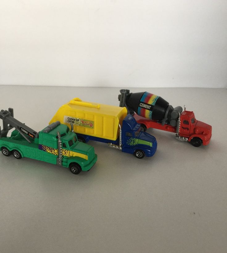 three toy trucks are lined up next to each other