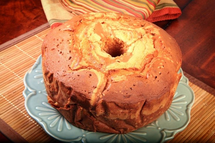 a bundt cake sitting on top of a blue plate next to a wooden table