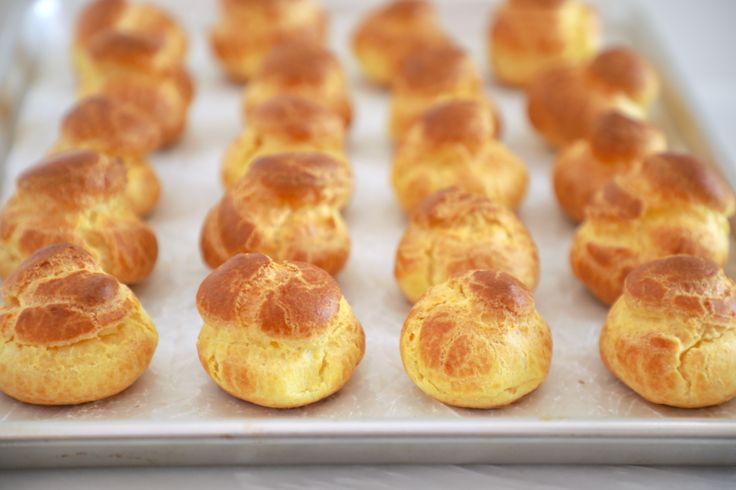 there are many small pastries on the baking pans ready to be baked in the oven