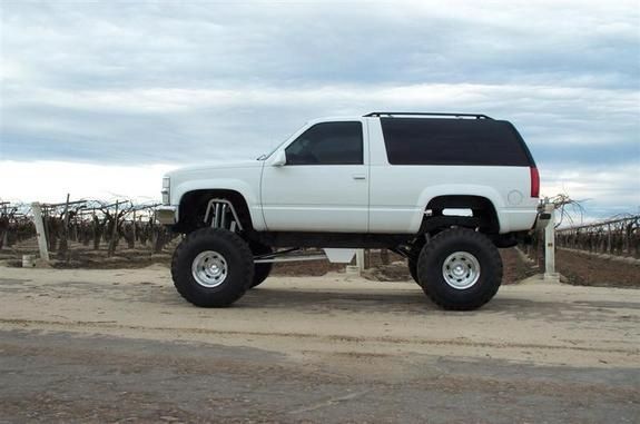 a white truck parked on top of a dirt road