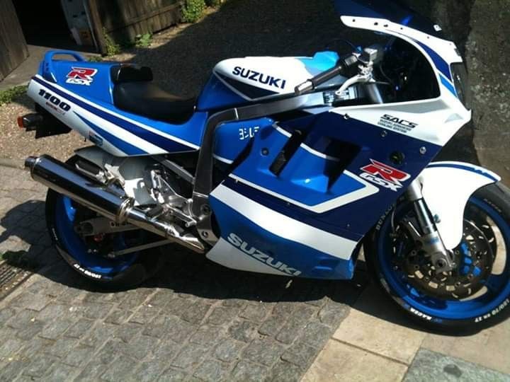 a blue and white motorcycle parked on the street