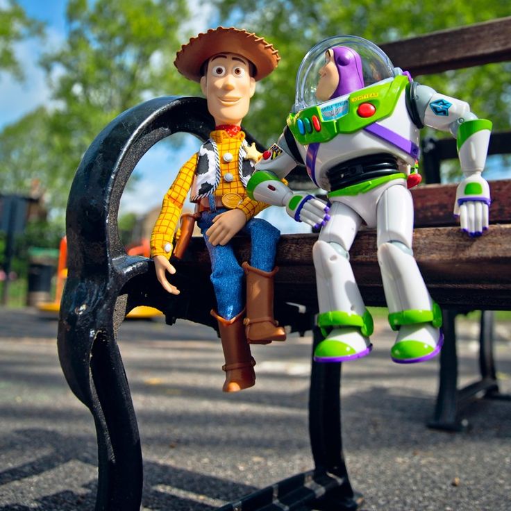 two toy figures sitting on top of a bench