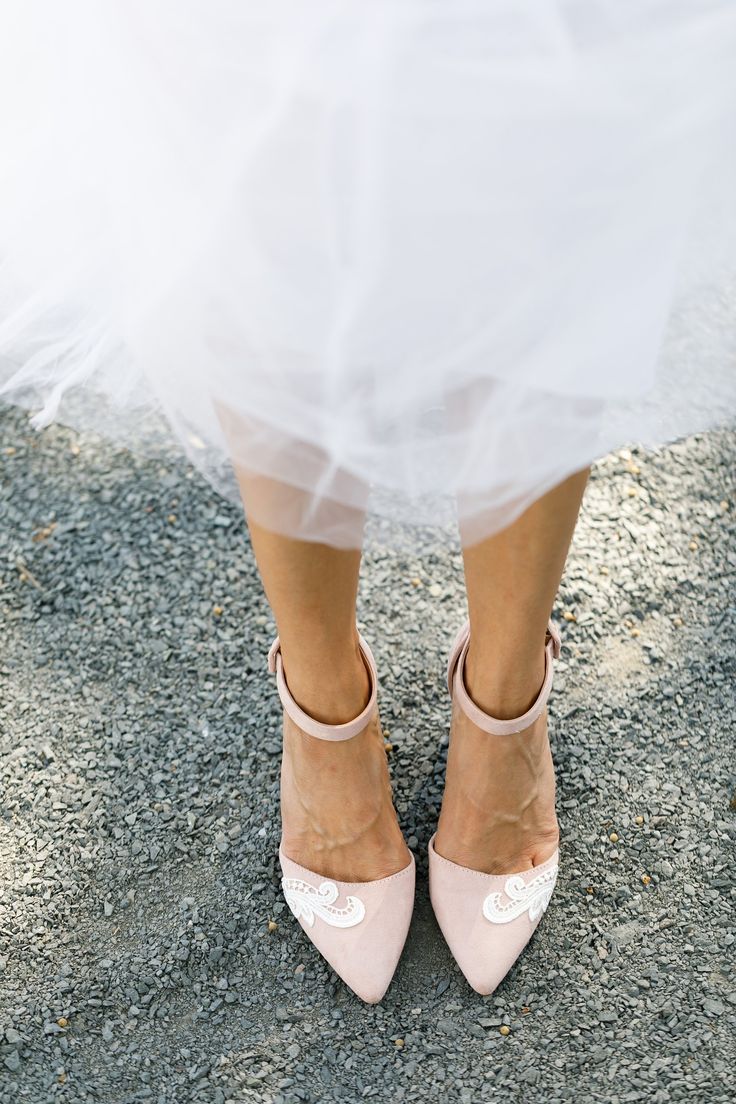 a bride's shoes and veil are seen in this photo taken from the waist up