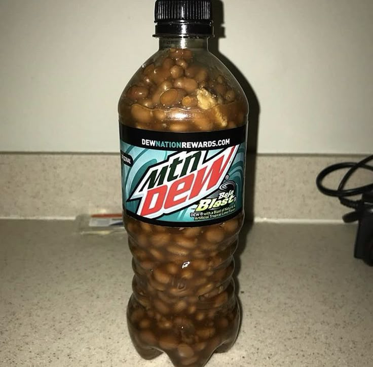 a bottle filled with nuts sitting on top of a counter