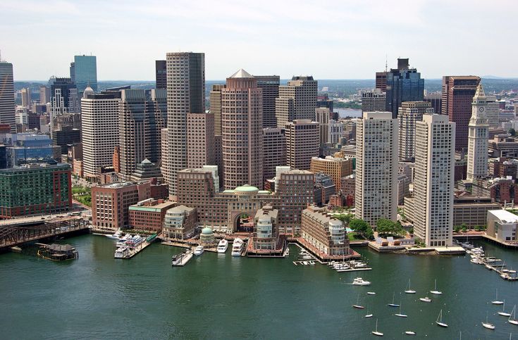 an aerial view of a city with boats in the water and tall buildings on both sides