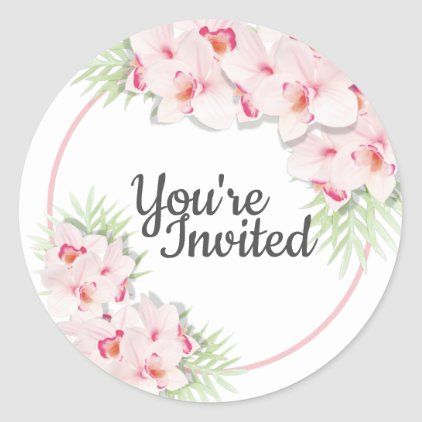 a round sticker with pink orchids and the words you're invited