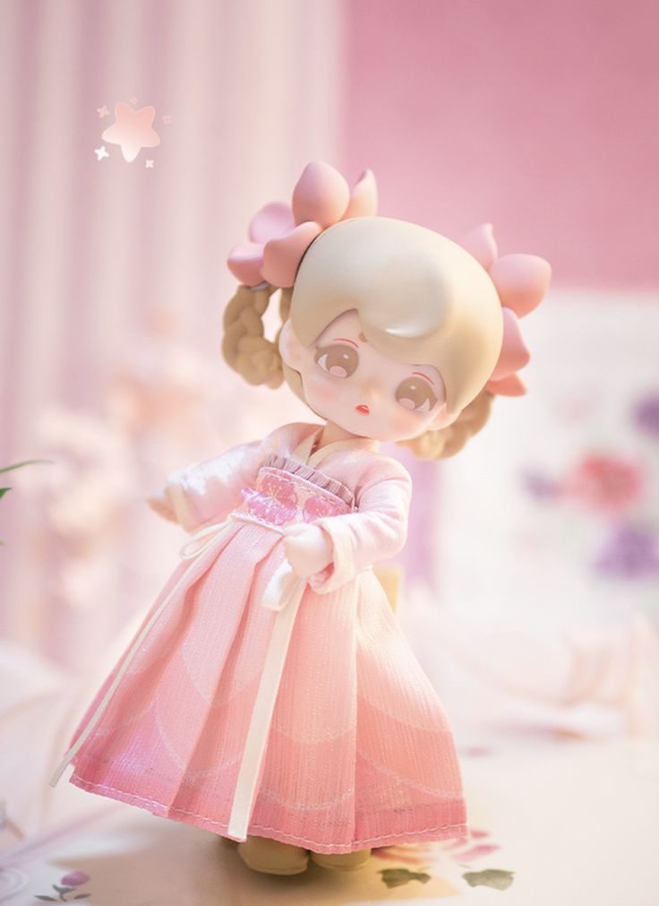 a doll is standing on a table with flowers in her hair and wearing a pink dress