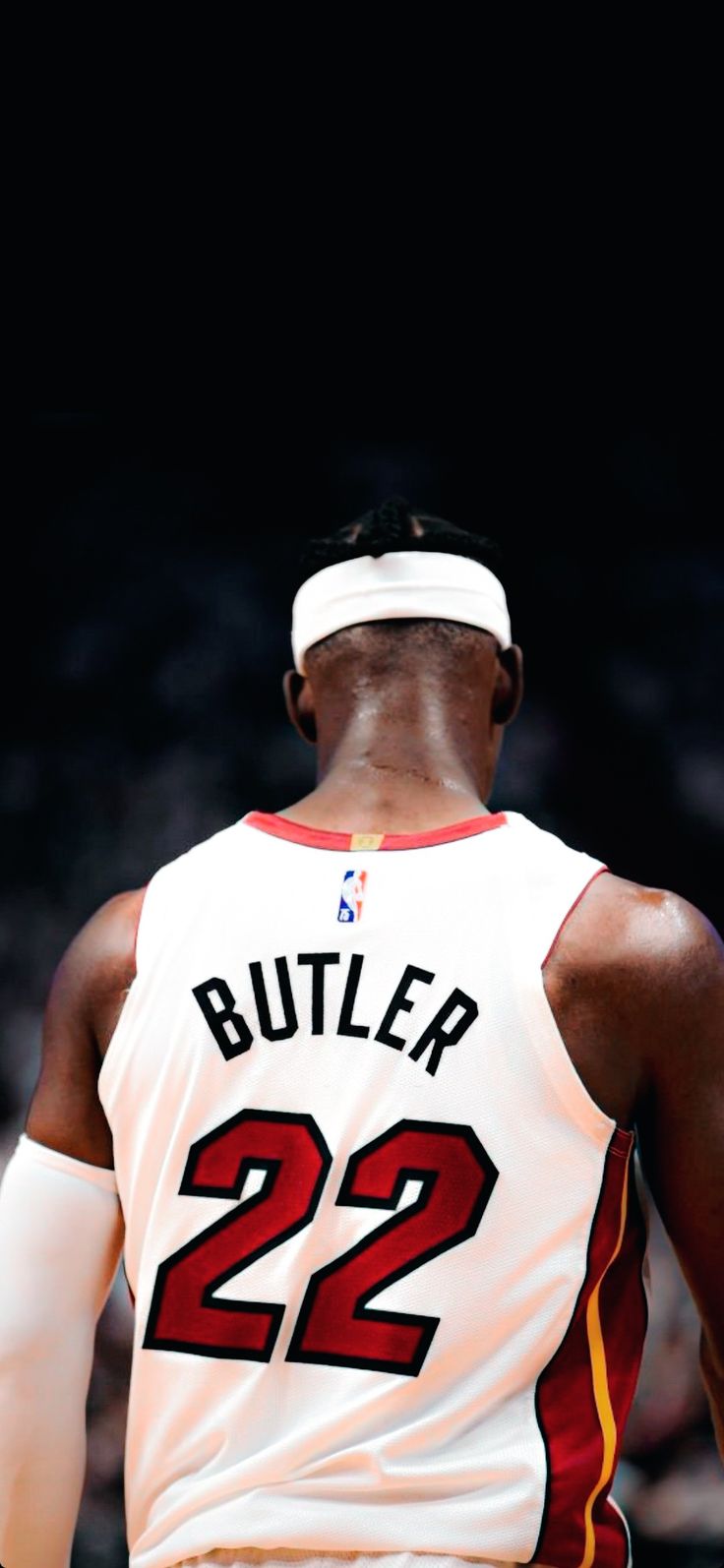 the back of a basketball player wearing a white jersey with red and yellow numbers on it