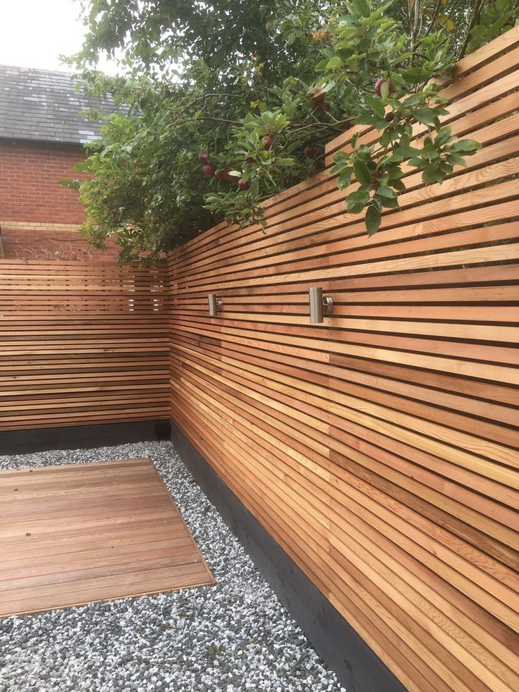 a wooden fence next to a gravel area