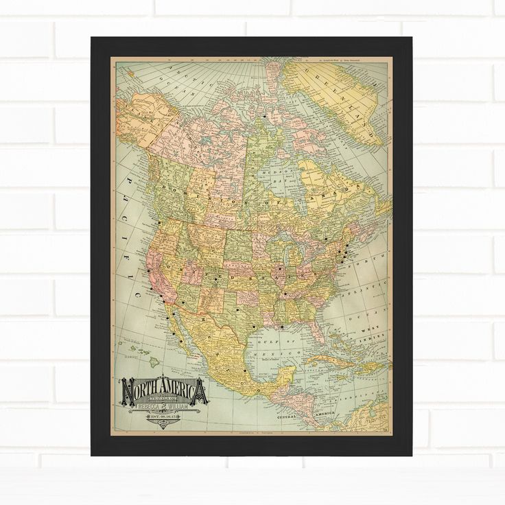 an old map of the united states in yellow and green, framed on a white brick wall