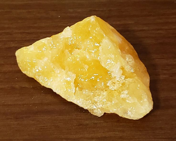 a piece of yellow rock sitting on top of a wooden table