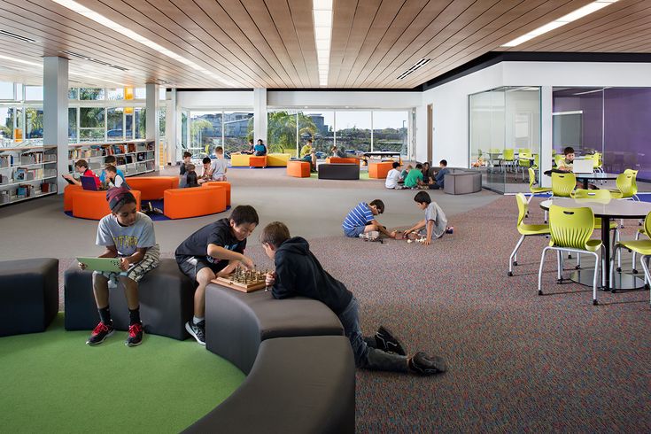 children are sitting in the library reading books