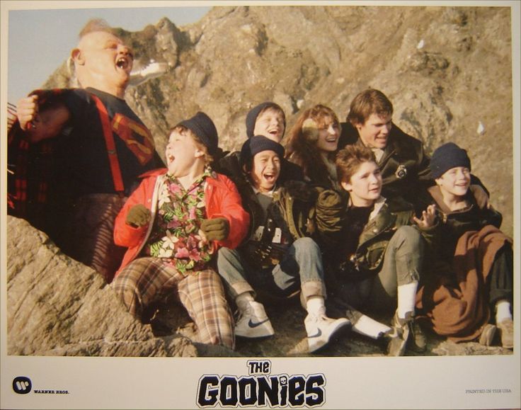 a group of young people sitting on top of a rocky mountain together, with the caption goonies