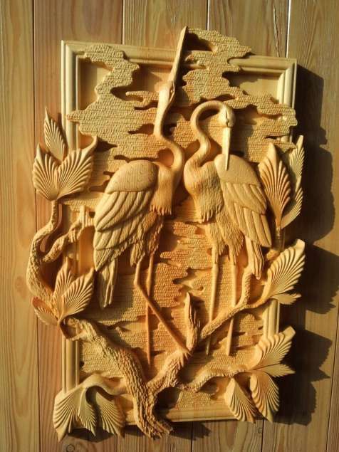 a carved wooden wall hanging with birds on it