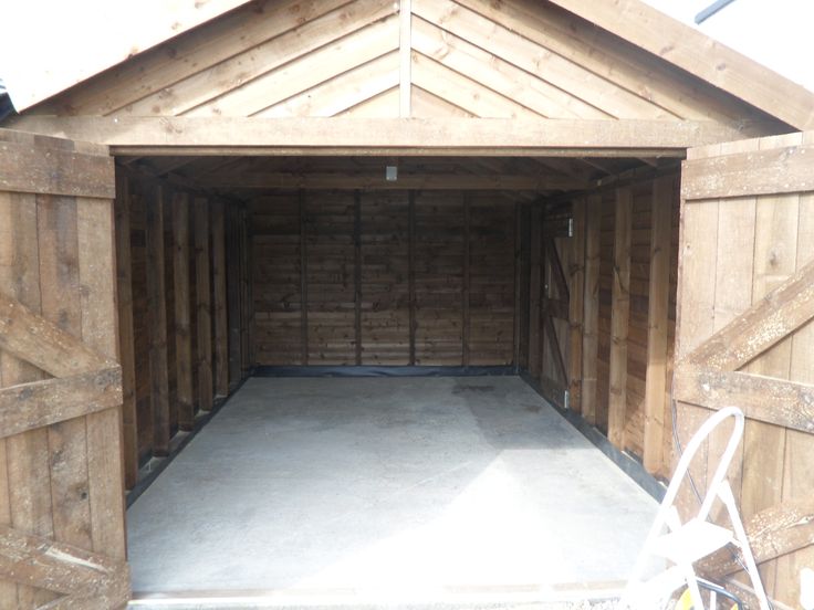 an empty garage with the doors open