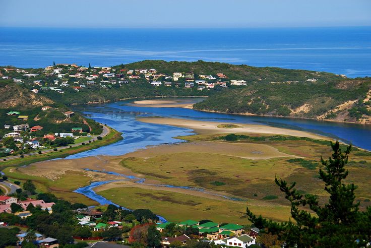 an aerial view of a small town by the water and land with houses on it