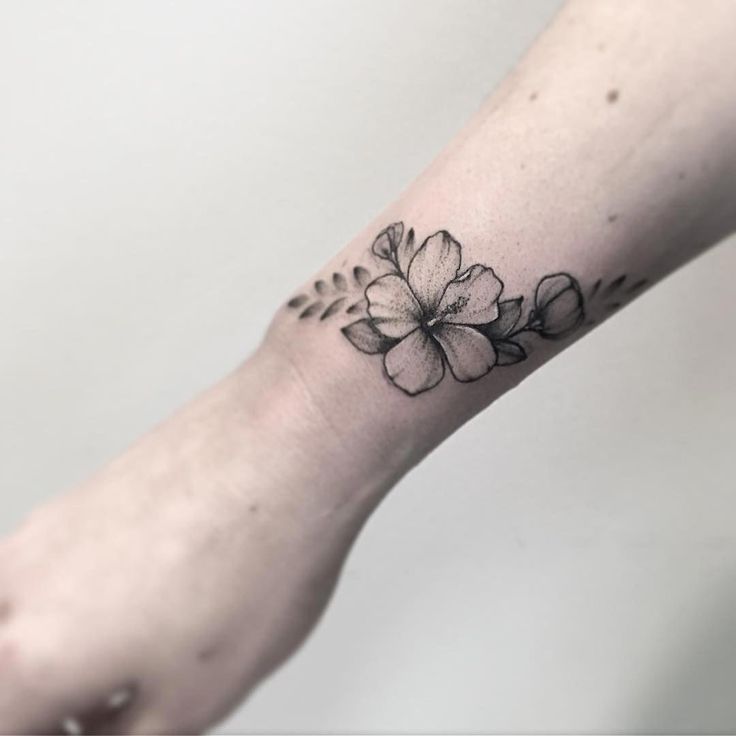 a small flower tattoo on the wrist