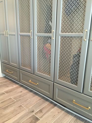 a kitchen with gray cabinets and wood floors