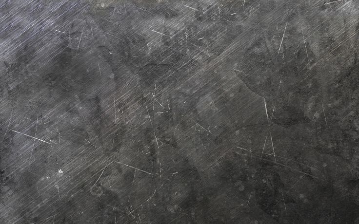 an old black metal plate with scratches on it