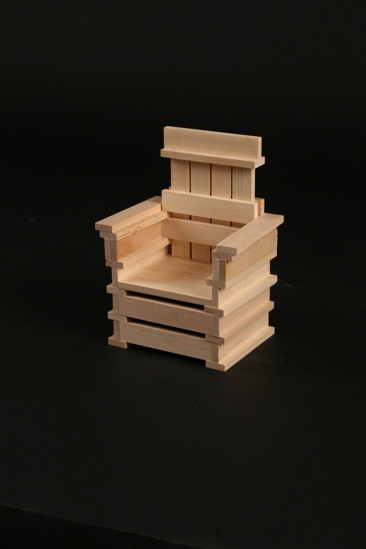 a small wooden box sitting on top of a black surface with the lid open and drawers closed