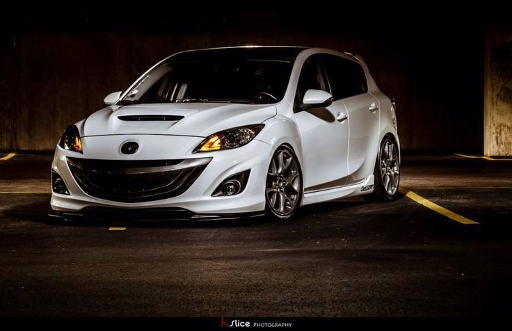 a white car parked in a parking lot at night