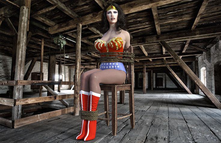 a woman sitting on top of a wooden chair in a room with wood floors and beams