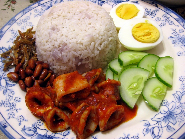 a blue and white plate topped with rice, meat and vegetables