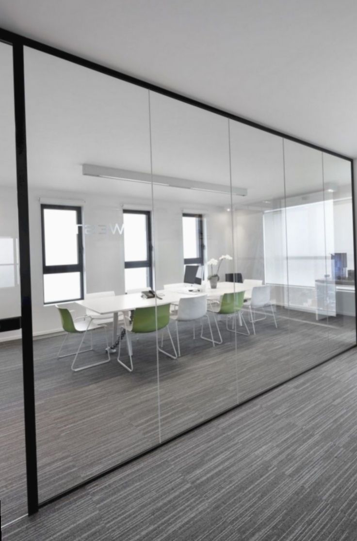 an empty conference room with glass walls and chairs