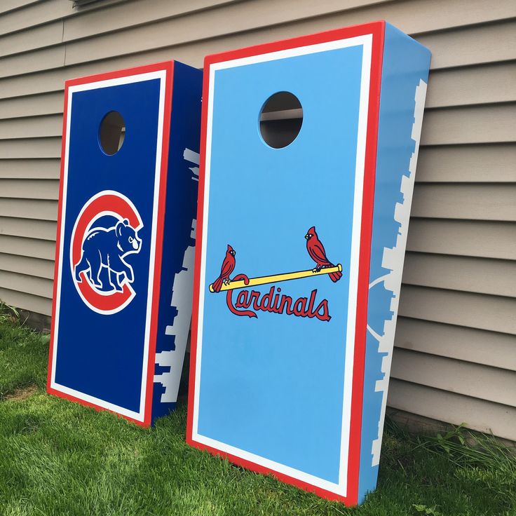 two blue and red cornhole game boards with the chicago cubs logo on them sitting in front of a house