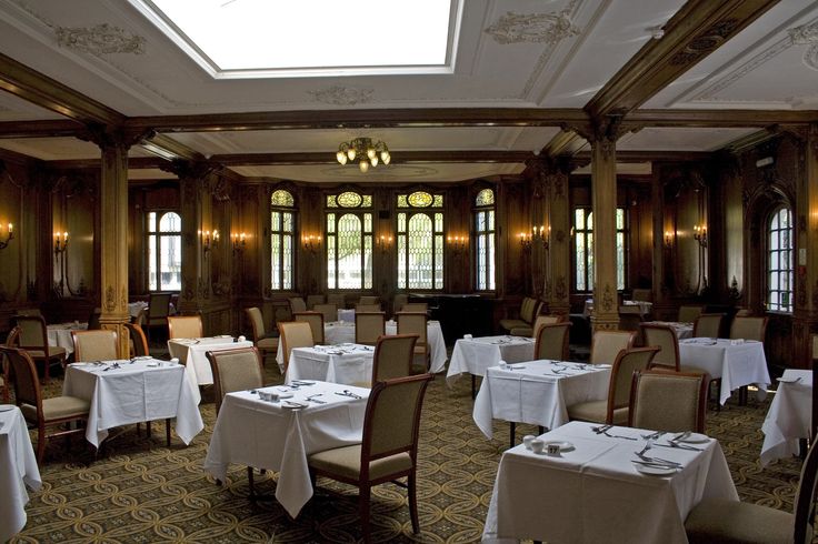 a dining room with tables and chairs covered in white tablecloths