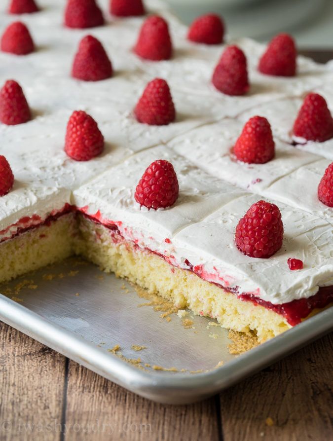 a cake with white frosting and raspberries on top