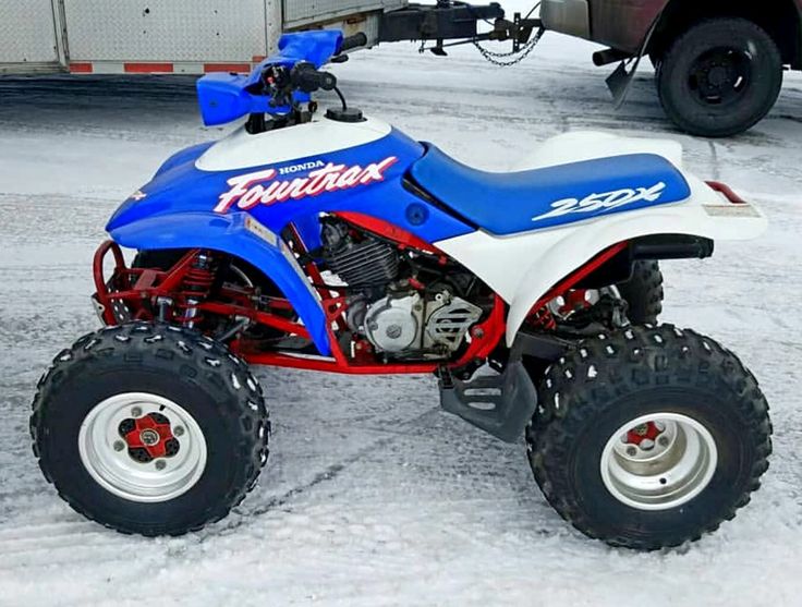 a blue and white four wheeler parked in the snow