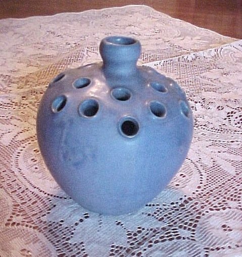 a blue vase sitting on top of a doily