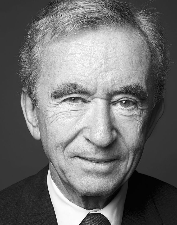 an older man in a suit and tie smiling at the camera with his eyes wide open