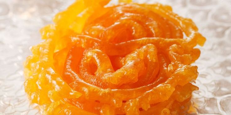 an orange flower sitting on top of a glass tablecloth covered in water droplets and flakes