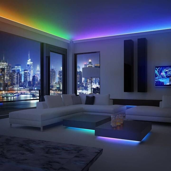 a living room filled with furniture and large windows overlooking the city skyline at night time