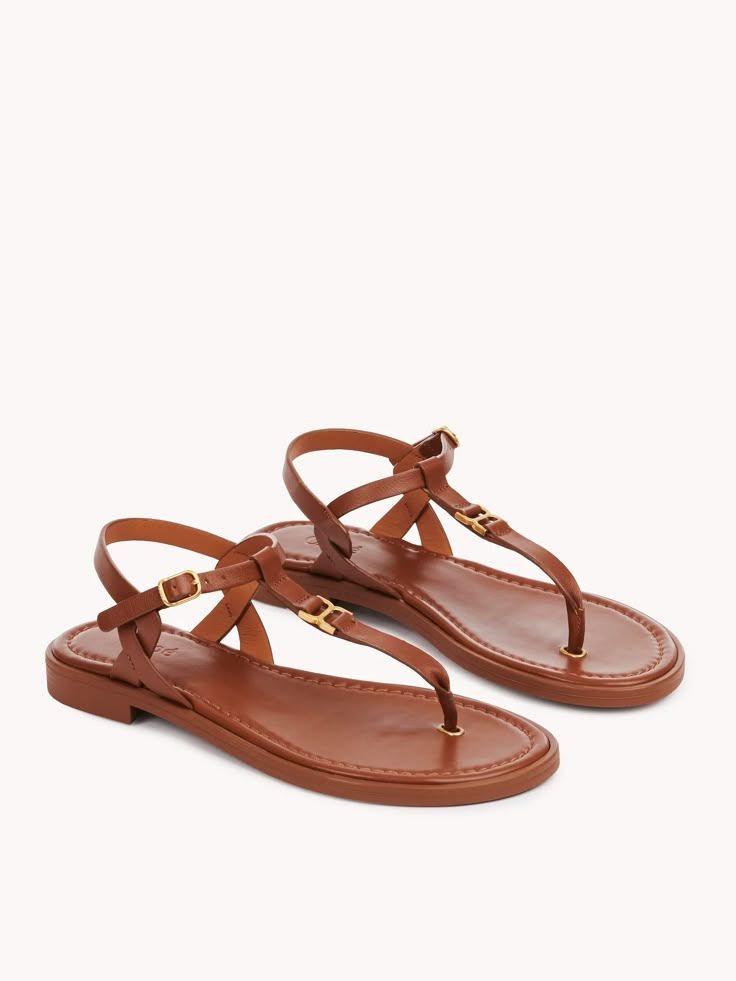 Chloé Marcie Flat Sandal | Chloé US Chic Calf Leather Sandals With Tang Buckle, Spring Calf Leather Sandals With Tang Buckle, Calf Leather Sandals With Tang Buckle, Elegant T-strap Sandals With Buckle Closure For Vacation, Flat Sandals With Tang Buckle, Elegant Slingback Sandals With Buckle For Vacation, Elegant Beach T-strap Sandals With Adjustable Strap, Chic Brown Sandals With Tang Buckle, Elegant T-strap Sandals With Single Toe Strap For Vacation