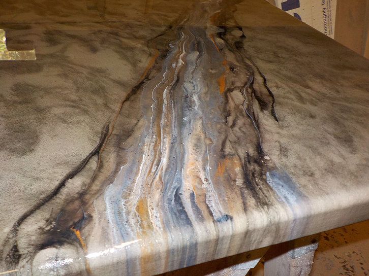 a marble table top that has been painted with different colors and patterns on the surface