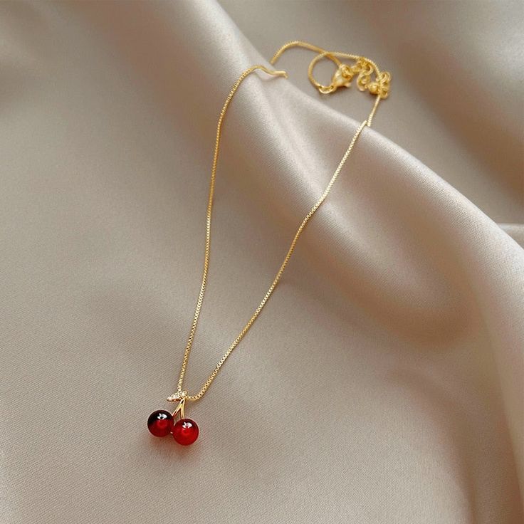 Enhance any outfit with this beautiful Wine Red Cherry Gold Pendant Necklace. Featuring a classic design and bold red hues, it will make a stunning fashion statement that will be admired by all. This statement piece is perfect for your collection. Red Round Jewelry, Red Clavicle Chain Jewelry For Valentine's Day, Elegant Cherry Colored Jewelry For Party, Cherry Jewelry For Valentine's Day Party, Cherry Color Jewelry For Valentine's Day Party, Cherry Colored Jewelry For Valentine's Day Party, Cherry-colored Jewelry For Valentine's Day Party, Trendy Red Pendant Necklace, Red Pendant Necklace For Valentine's Day