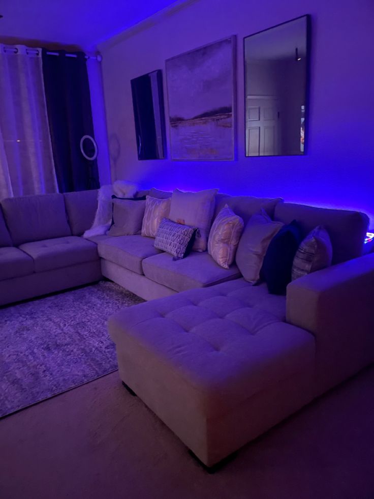 a living room filled with furniture and purple lighting