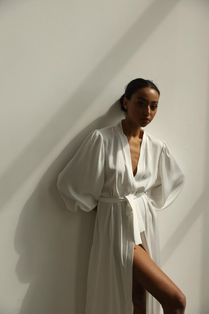 Our long bridal silk robe with wide long sleeves. It could be made of satin or pure mulberry silk. The robe is both casual and elegant, you may wear it on the hen party or spontaneously around your home on a daily basis. It is also an amazing outfit for your vocation, to wear it on the beautiful beach or by the pool as a cover up. -Our model wears size XS, her measurements are 82/61/87 cm and she is 172 cm tall. -Attached with belt. -Arrives beautifully packaged in tissue paper with ribbon -Leng Satin V-neck Robe For Daywear, Elegant V-neck Robe For Daywear, Elegant Summer Sleep Robe, White V-neck Robe For Sleep, Satin V-neck Daywear Robe, Elegant V-neck Kimono For Daywear, Elegant Summer Wrap Sleepwear, Feminine White Robe For Sleep, Chic Silk Robe For Sleeping