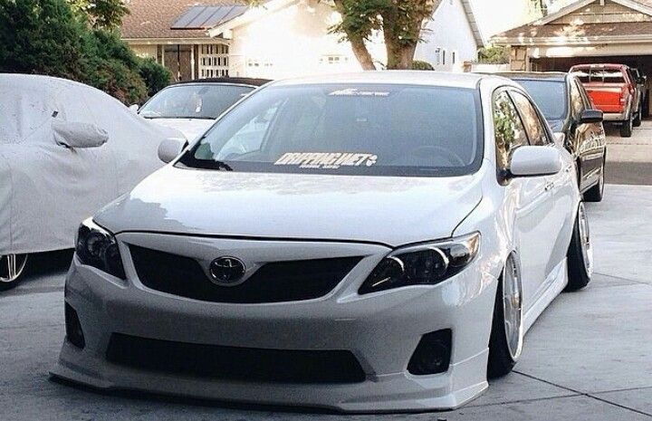 a white car parked in front of a house