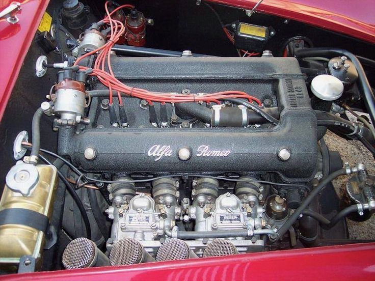 the engine compartment of an old red sports car