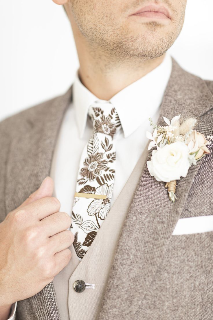 a man wearing a suit and tie with flowers on the lapel