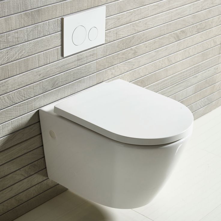 a white toilet sitting in a bathroom next to a wall mounted plaque with the word c on it