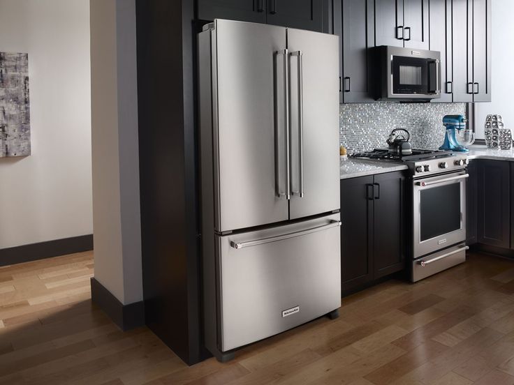 a kitchen with stainless steel appliances and black cabinets