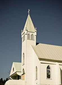 a white church with a steeple and cross on top