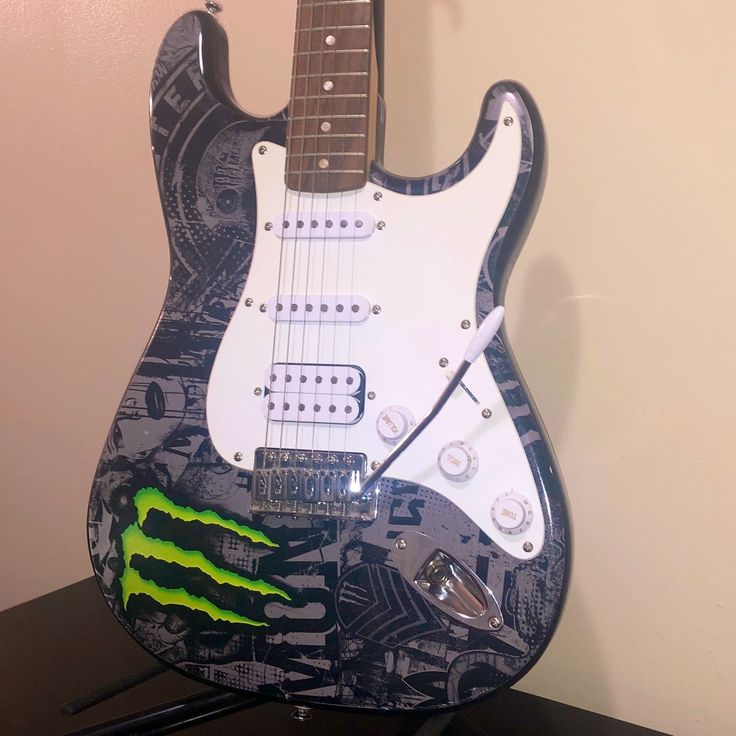 a black and white guitar with neon green paint on it